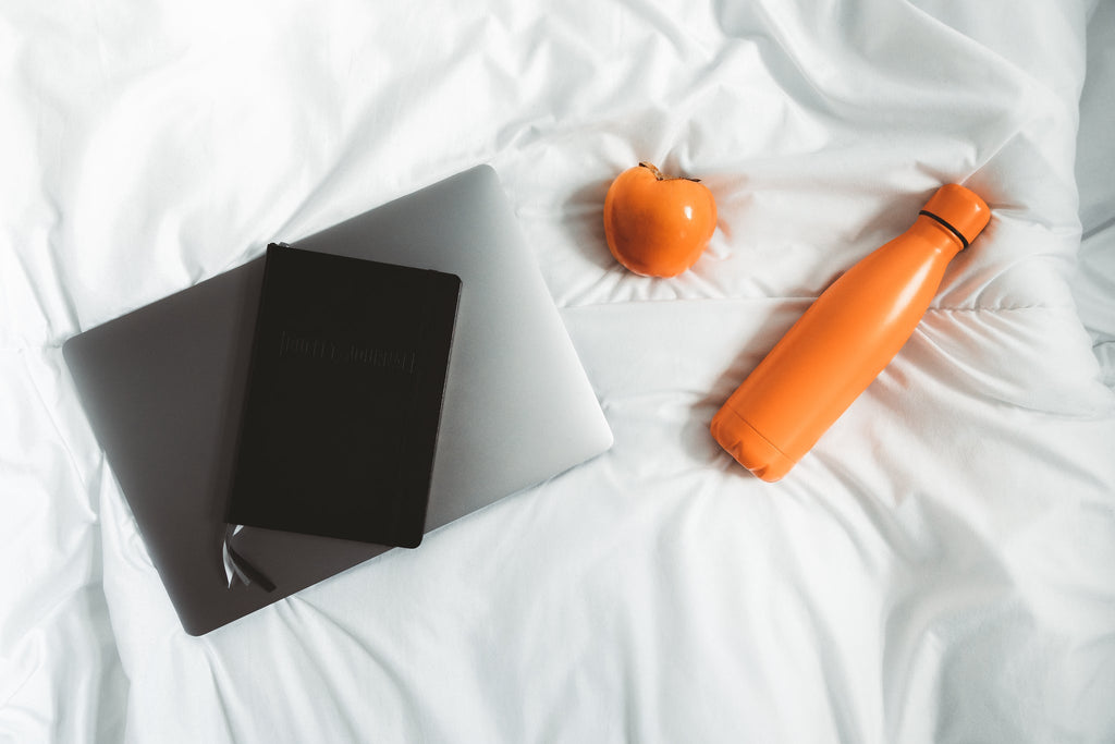 Steel Water Bottle beside a laptop